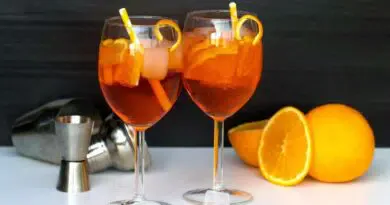 Zwei Gläser Cocktail mit Orangenscheiben und Eis.