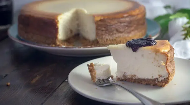 Ein Käsekuchen auf einem Teller mit einer Gabel.