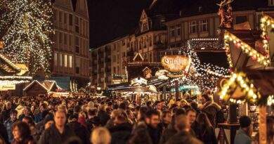 Ein überfüllter Weihnachtsmarkt in einer Stadt.