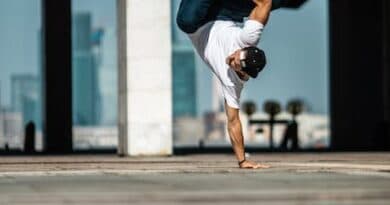 Ein Mann macht einen Handstand in einer Wasserpfütze.