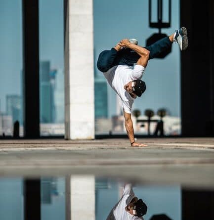 Ein Mann macht einen Handstand in einer Wasserpfütze.