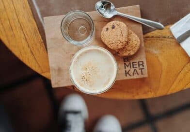 Eine Tasse Kaffee und Kekse auf einem Holztisch.