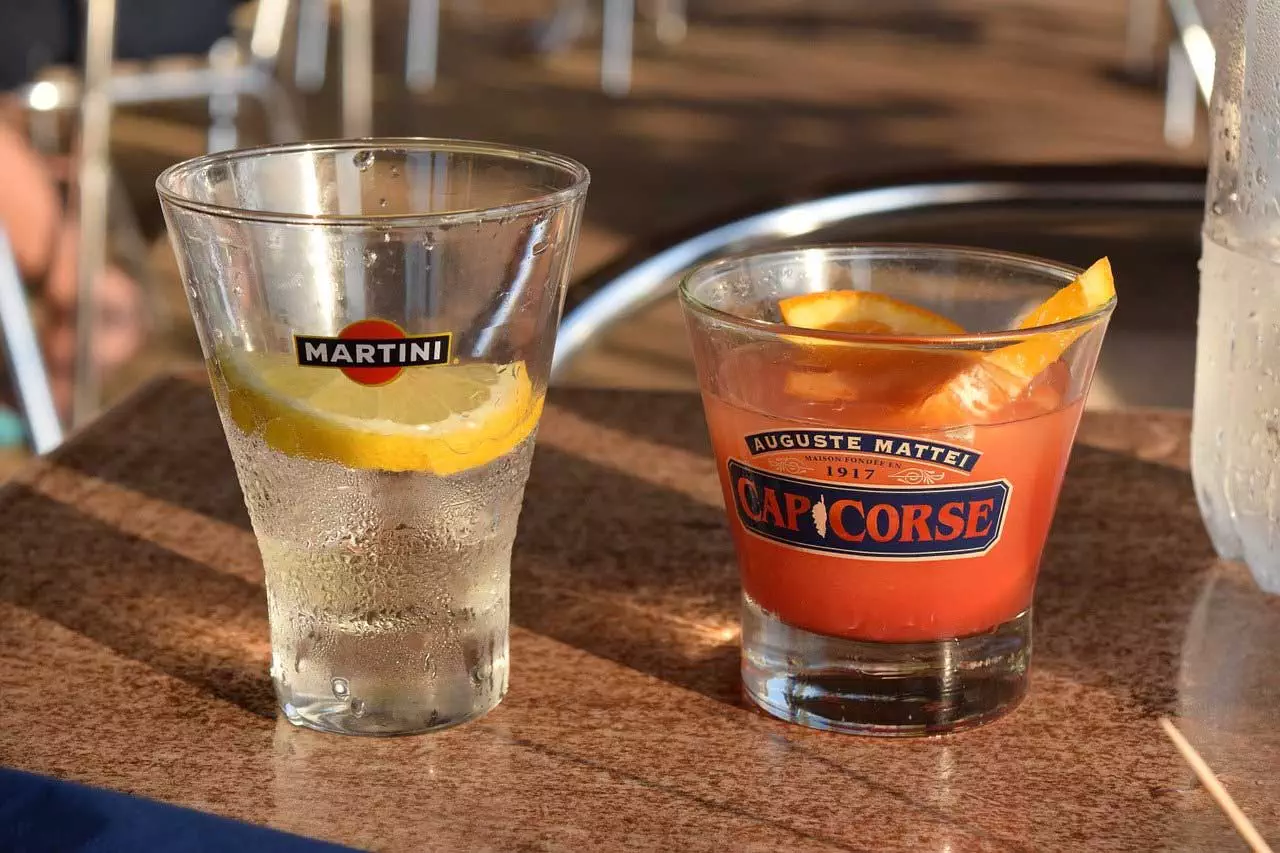 Ein Glas Wasser und ein Glas Orangensaft auf einem Tisch.