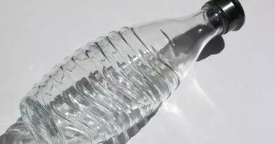 Eine Sodastream-Flasche mit schwarzem Deckel auf einer weißen Oberfläche.
