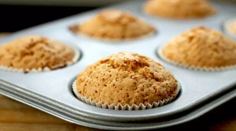 Low-Carb-Muffins in einer Muffinform auf einem Holztisch.