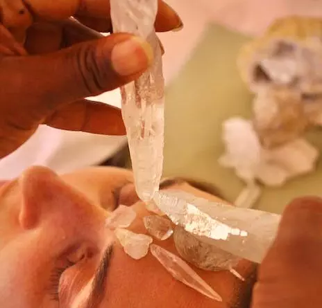 Eine Frau erhält eine Kristallbehandlung im Gesicht.