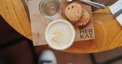 Eine Tasse Kaffee und Kekse auf einem Holztisch.