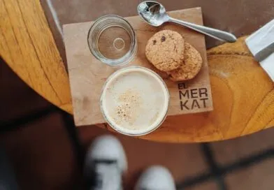 Eine Tasse Kaffee und Kekse auf einem Holztisch.
