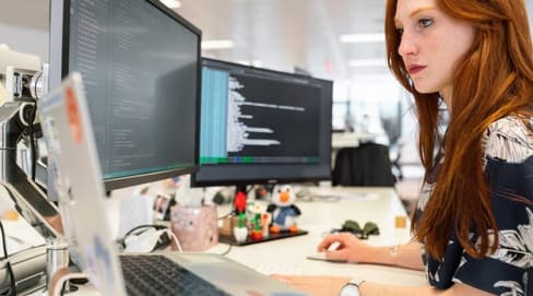 Eine Frau, die in einem Büro an einem Computer arbeitet.