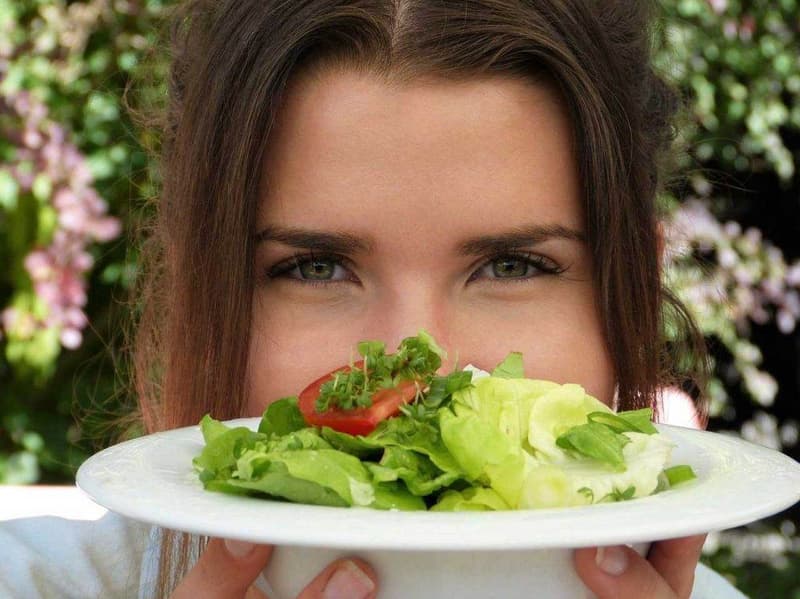 Eine Frau hält einen Teller Salat.