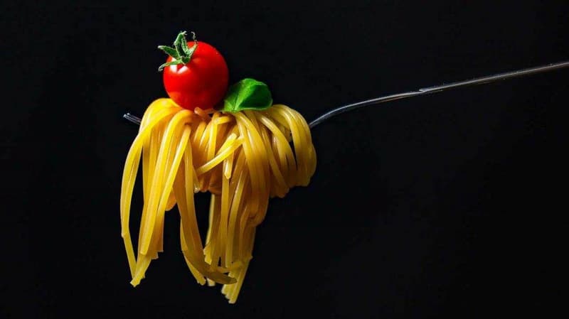 Eine Gabel mit einer Tomate darauf.