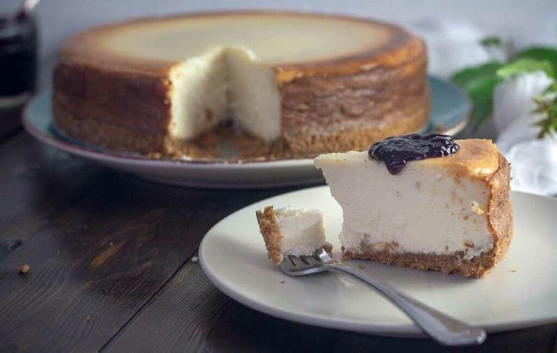 Ein Käsekuchen auf einem Teller mit einer Gabel.
