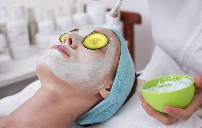 Eine Frau erhält eine Gurken-Gesichtsmaske in einem Spa.