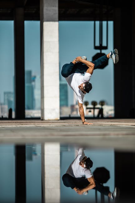 Ein Mann macht einen Handstand in einer Wasserpfütze.